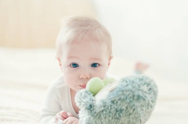 Yakışıklı, neşeli çocuk yatakta emekliyor..