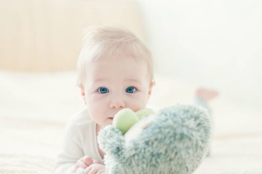 Yakışıklı, neşeli çocuk yatakta emekliyor..