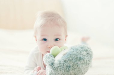 Yakışıklı, neşeli çocuk yatakta emekliyor..