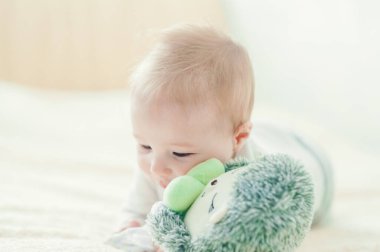 Yakışıklı, neşeli çocuk yatakta emekliyor..