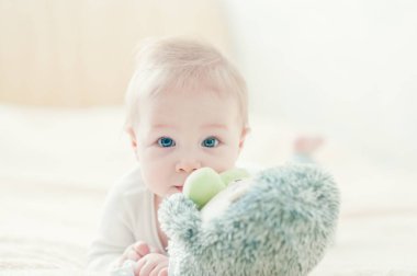 Yakışıklı, neşeli çocuk yatakta emekliyor..