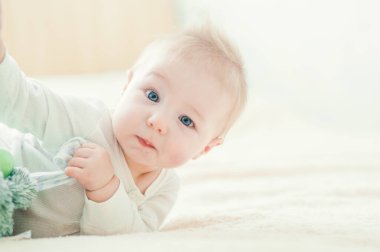 Yakışıklı, neşeli çocuk yatakta emekliyor..