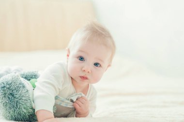 Yakışıklı, neşeli çocuk yatakta emekliyor..