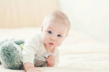 Yakışıklı, neşeli çocuk yatakta emekliyor..