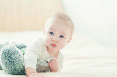 Yakışıklı, neşeli çocuk yatakta emekliyor..