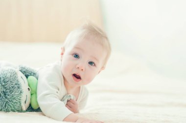 Yakışıklı, neşeli çocuk yatakta emekliyor..