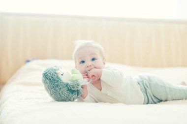 Yakışıklı, neşeli çocuk yatakta emekliyor..