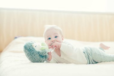 Yakışıklı, neşeli çocuk yatakta emekliyor..