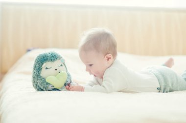 Yakışıklı, neşeli çocuk yatakta emekliyor..