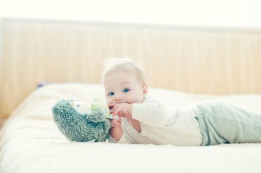 Yakışıklı, neşeli çocuk yatakta emekliyor..