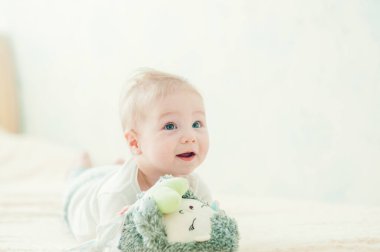 Yakışıklı, neşeli çocuk yatakta emekliyor..