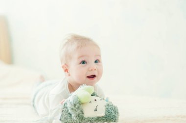 Yakışıklı, neşeli çocuk yatakta emekliyor..