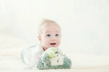 Yakışıklı, neşeli çocuk yatakta emekliyor..