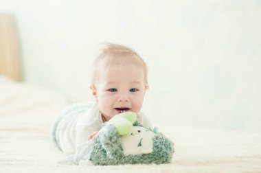 Yakışıklı, neşeli çocuk yatakta emekliyor..