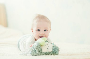 Yakışıklı, neşeli çocuk yatakta emekliyor..