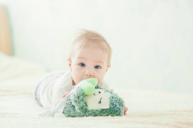 Yakışıklı, neşeli çocuk yatakta emekliyor..