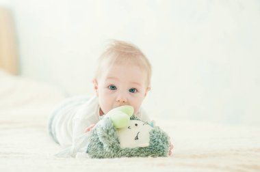 Yakışıklı, neşeli çocuk yatakta emekliyor..