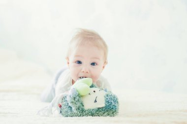 Yakışıklı, neşeli çocuk yatakta emekliyor..