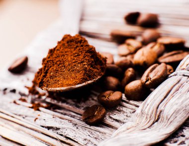 Aromatik kahve çekirdekleri. Hazır kahve fırçası hazır. Kahve çekirdekleri, kahve çekirdekleri, kavrulmuş kahve çekirdekleri, kaşık ezilmiş kahve, şeker küpleri.