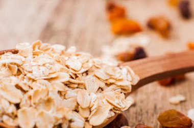 Tahta bir masanın üzerindeki yulaf lapası, yulaf ezmesi. Cömert hasat. Sağlıklı taze bir kuru yulaf yemeği.