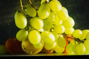 Su damlaları ile taze yeşil üzüm.