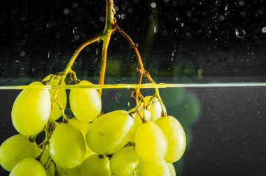 Su damlaları ile taze yeşil üzüm.