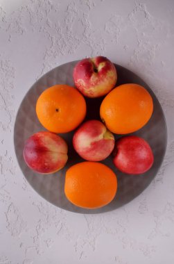 Taze meyve. Nektarinler ve portakallar masada..