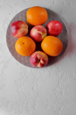 Taze meyve. Nektarinler ve portakallar masada..