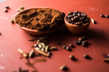 Kahve çekirdekleri masada ve tarçınlı. Kahve masanın üstünde..