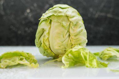 Masada taze yeşil lahana var. Sebzeler faydalı vitaminler, vejetaryenler için yiyecekler. Sebze dilimleyici..