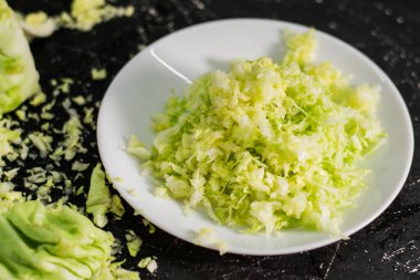 Masada taze yeşil lahana var. Sebzeler faydalı vitaminler, vejetaryenler için yiyecekler. Sebze dilimleyici..