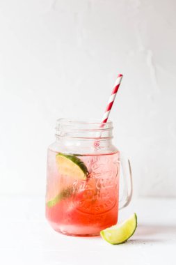 Beyaz bir zemin ve arka planda çizgili saman ile pembe limonata