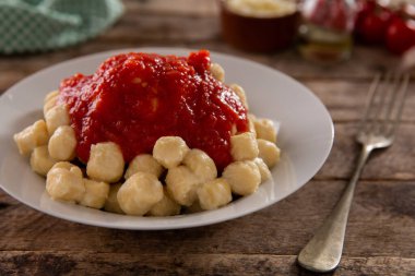 Beyaz tabakta gnocchi ve marinara sosu.