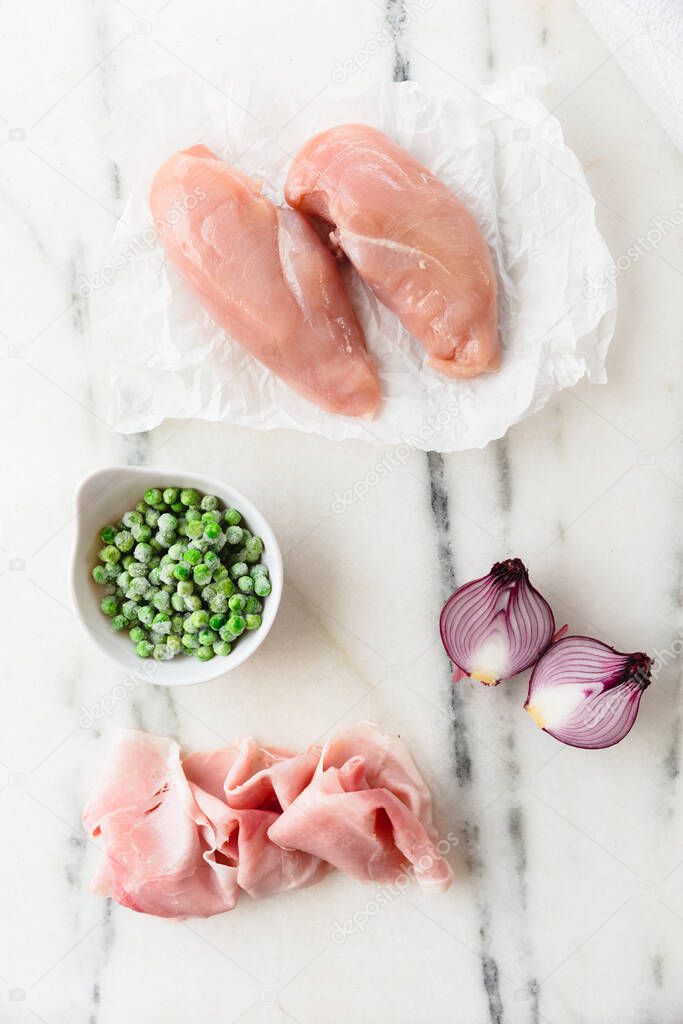 Raw Chicken breats with red onions, frozen peas and ham