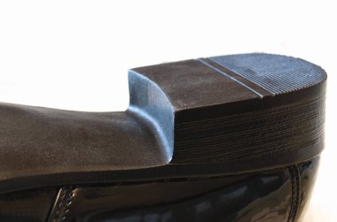 Bir erkek ayakkabısının topuğu. Deri ayakkabı tabanı. Beyaz arkaplan