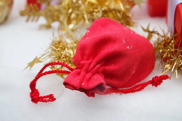 Saco de Natal vermelho com presentes na neve — Fotografia de Stock