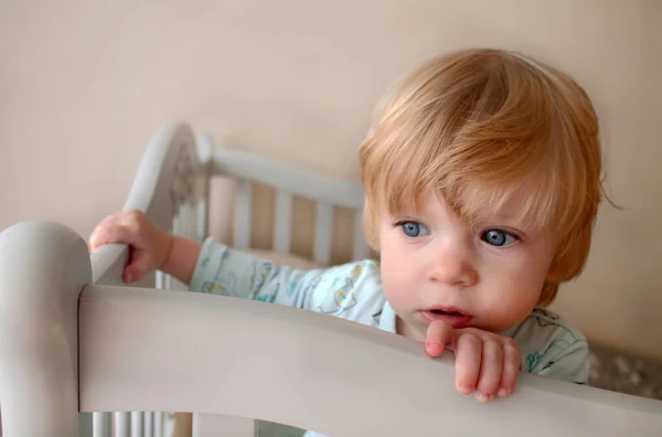 Baby in crib looks surprised — Stock Photo, Image