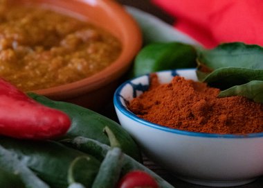 Taze kırmızı ve yeşil biber ve ahşap zeminde taze acı biber tozları. 