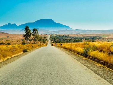 Madagaskar 'ın çarpıcı manzarası, Route Nationale 7 (RN7) ve arka planda ünlü Kardinal şapkası, Andringitra Massif' in bir parçasını oluşturan devasa granit dağ