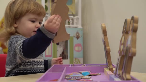 4k krullend schattige baby geniet van zijn speelgoed in in de kleuterschool — Stockvideo