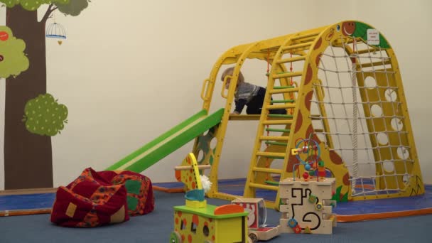4 k niedliches kleines Kind, das auf einem Kinderspielplatz im Zimmer spielt — Stockvideo
