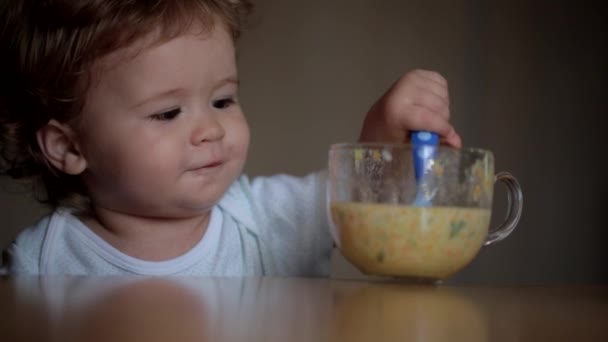 Bebê bonito se divertindo comendo seu almoço e sorrindo — Vídeo de Stock