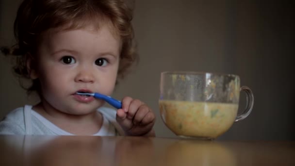 Belle enfant aux cheveux bouclés mange à la table — Video