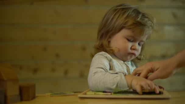 Maman aide son fils à déposer une image de puzzles — Video