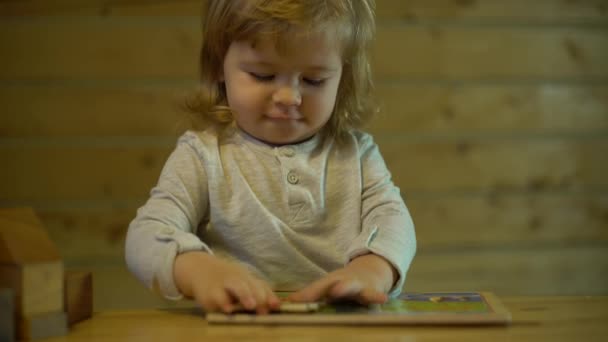 Padre ayuda al niño a poner rompecabezas de madera en la mesa — Vídeos de Stock