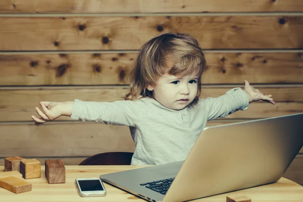 Menino pequeno com computador e telefone — Fotografia de Stock