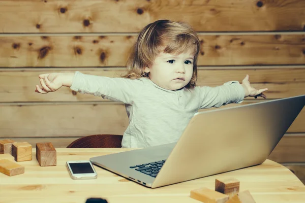 Kleine jongen met computer en telefoon — Stockfoto