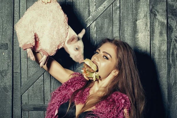 Flicka med hamburgare och gris — Stockfoto