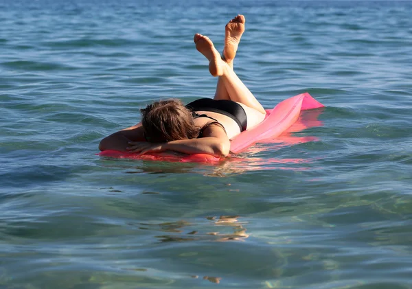 Femme sur matelas en mer — Photo