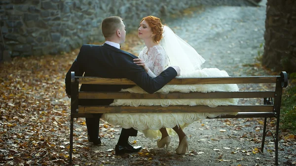 Pareja de boda en el banco — Foto de Stock